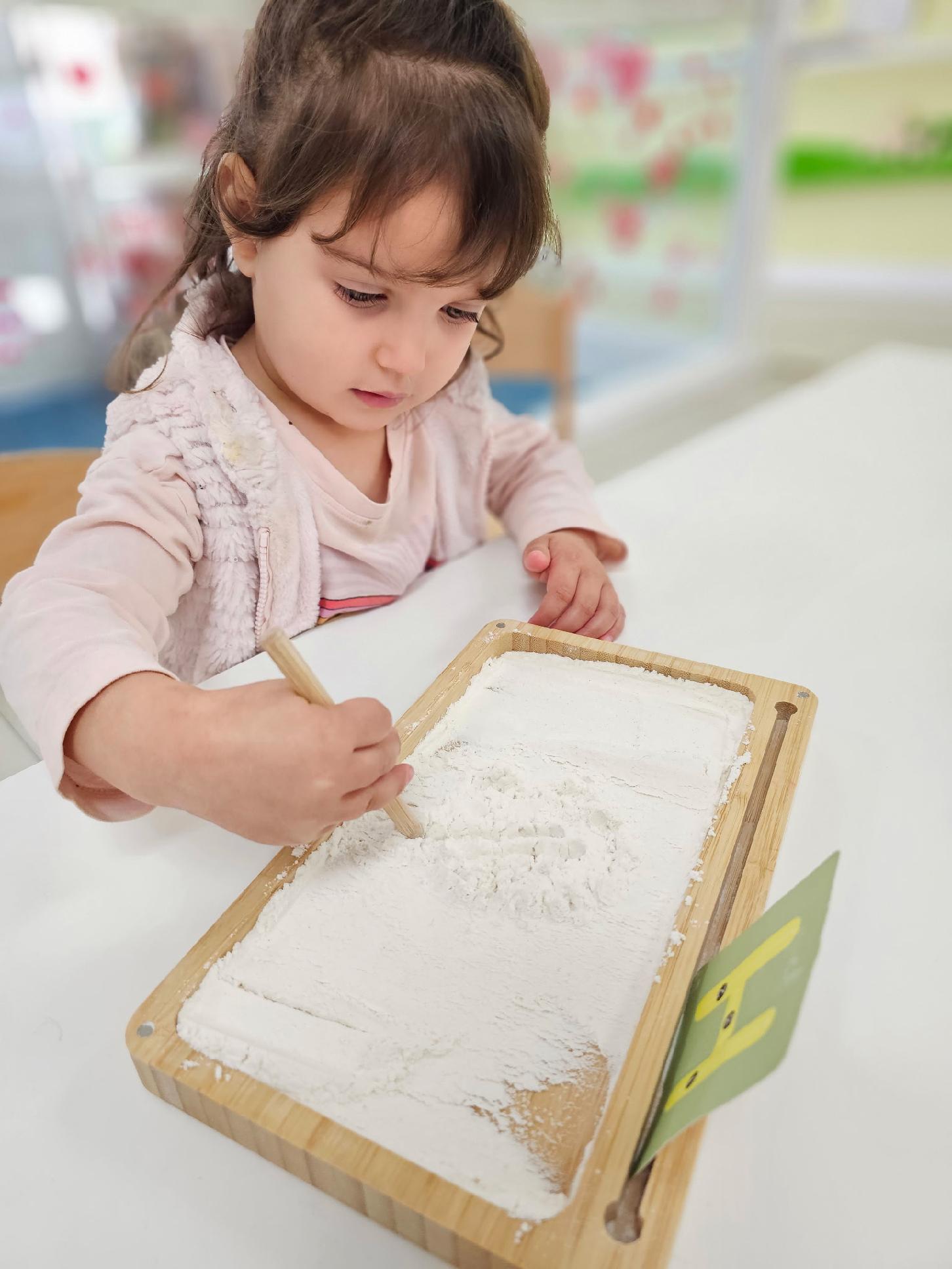 Child working independently with Montessori materials at a low table